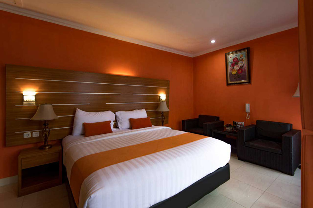 Kamar Hotel Bintang 3 Dinding Warna Orange Sofa Hitam Kasur Bed Cover Bantal Guling Putih Bersih Bed Scraf Orange