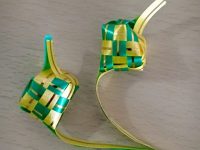 Handwoven green and yellow woven basket sits on plain surface