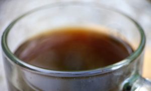 Warm coffee in clear glass mug