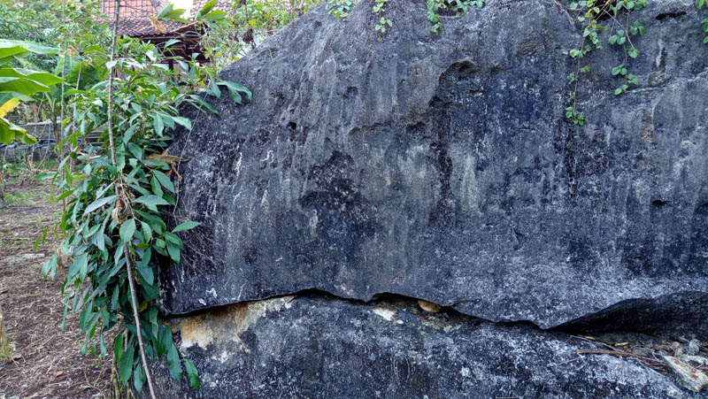 Rugged dark rock stands tall, weathered and ancient