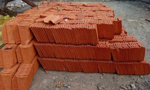 Stacks of red clay tiles lie neatly arranged