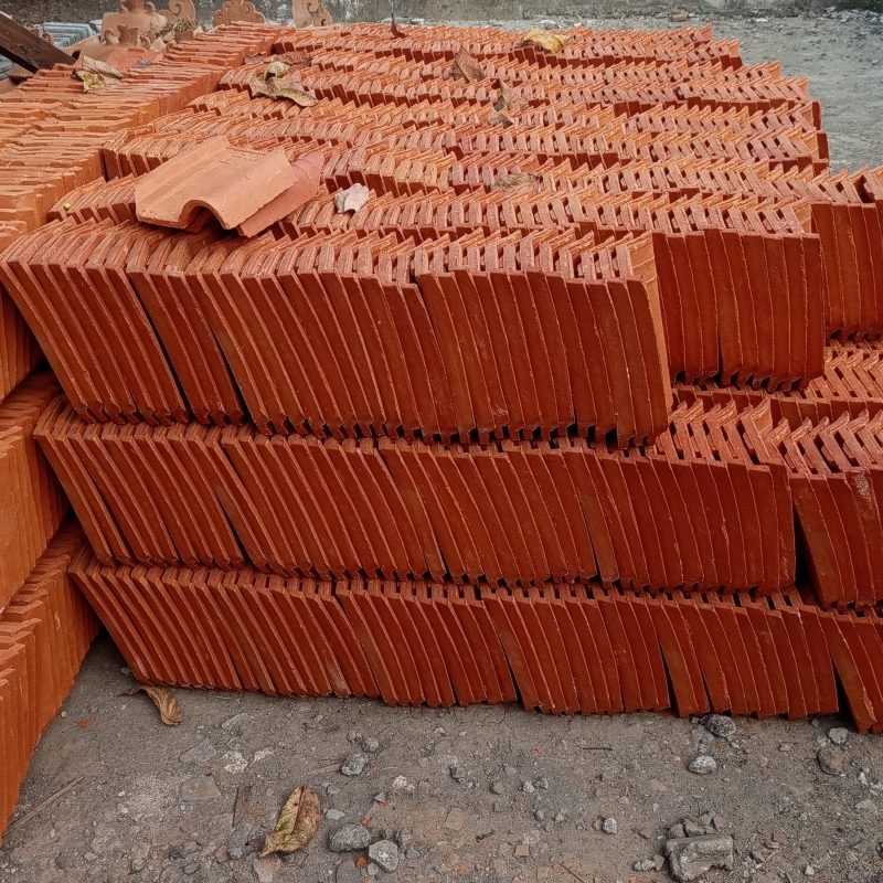 Stacks of red clay tiles lie neatly arranged
