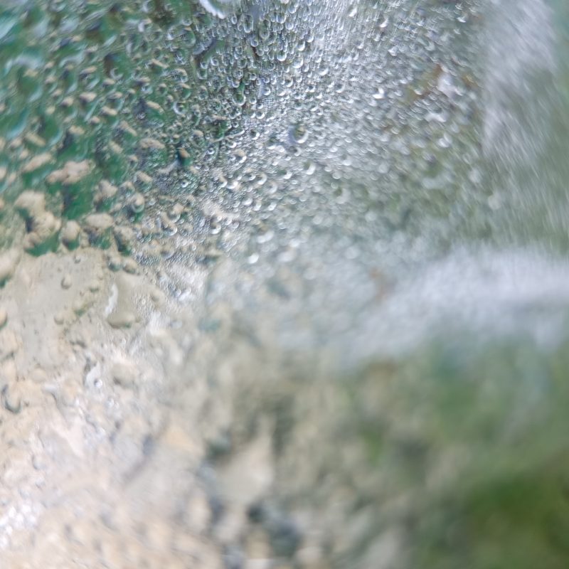 Ocean wave crashes, bubbles burst, water churns
