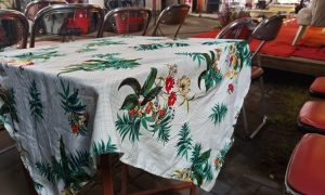 Tropical tablecloth drapes a wooden table