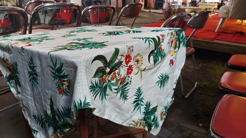Tropical tablecloth drapes a wooden table